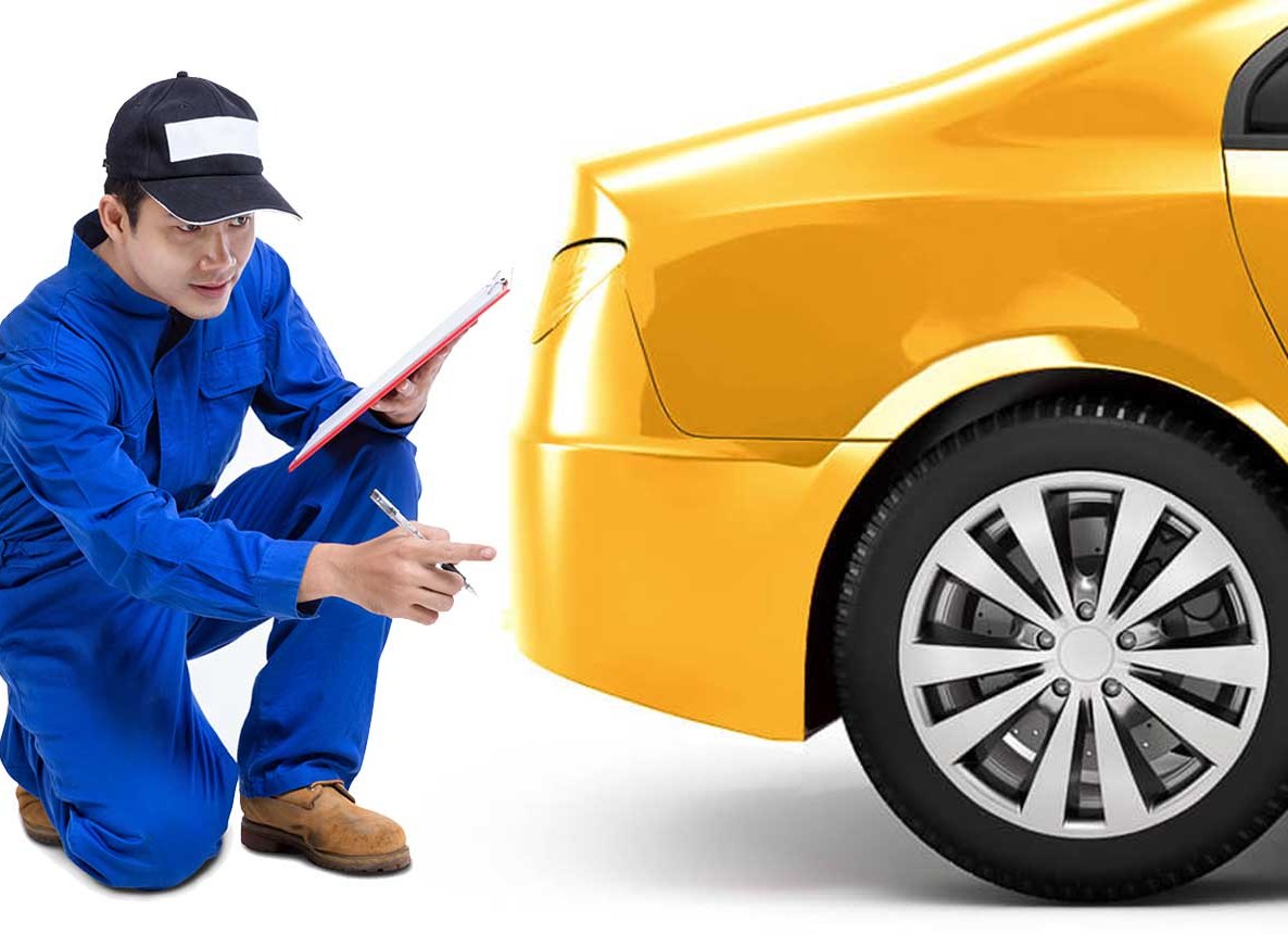 Prüfer mit Klemmbrett begutachtet das Heck eines gelben Fahrzeugs